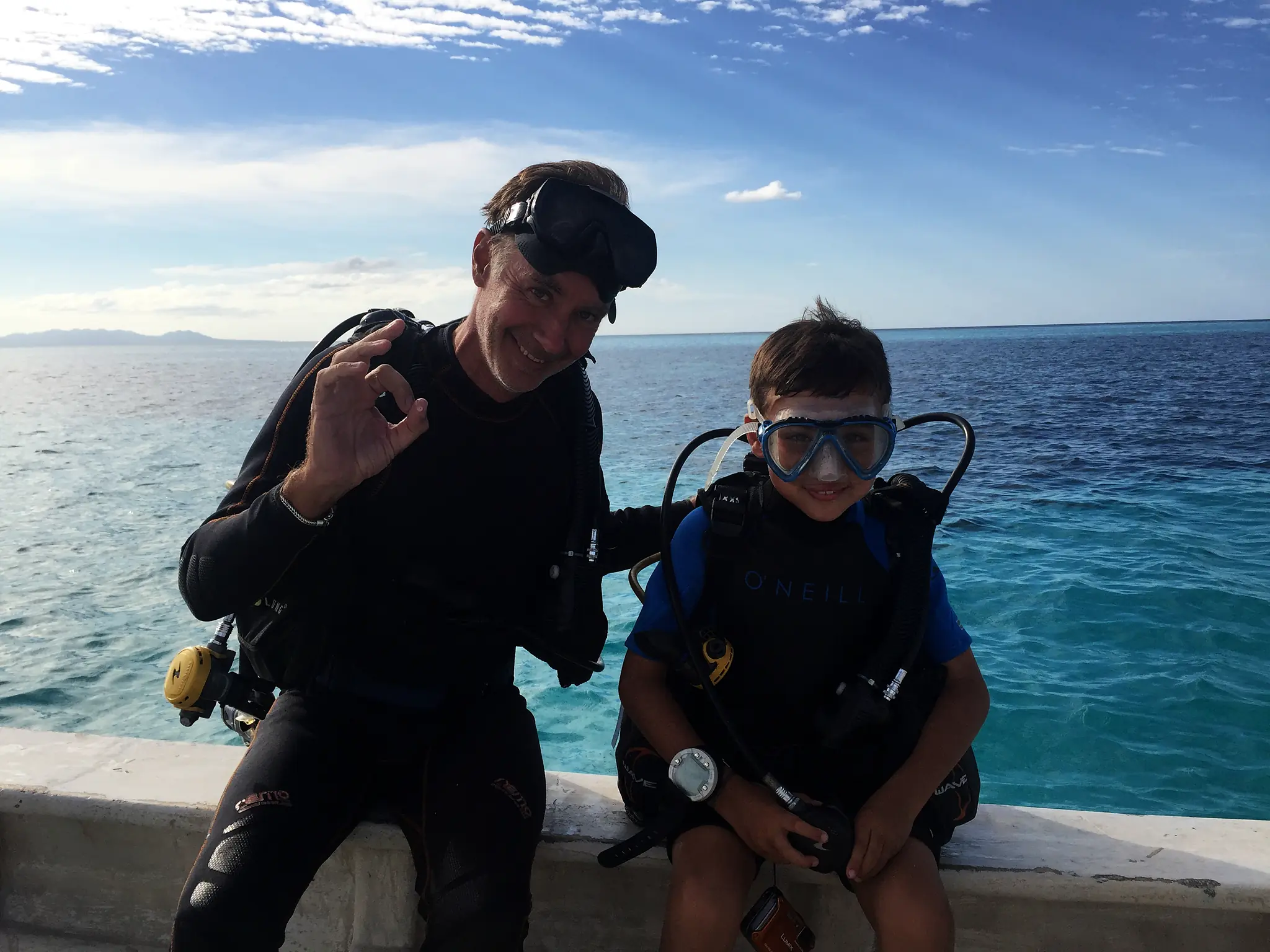 an instructor and a young diver giving the OK sign
